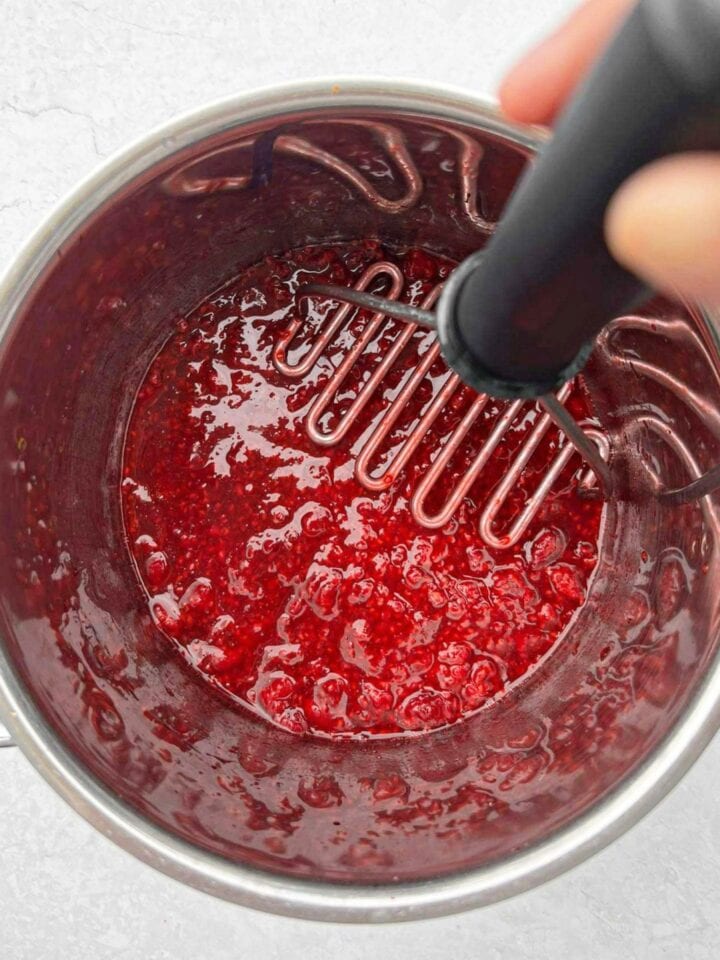 Mashing raspberries in a saucepan. 