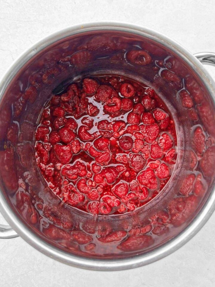Raspberries and maple syrup in a saucepan.