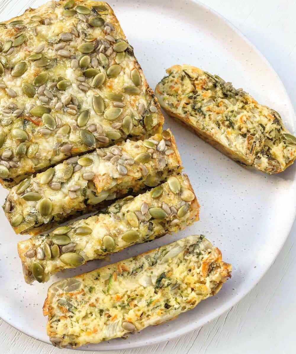 A thickly sliced cheddar and vegetable loaf topped with seeds.