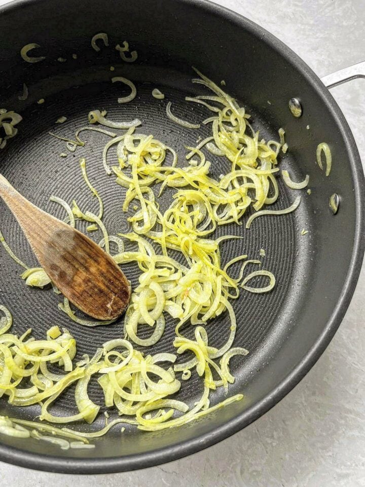 Sautéd half-moon brown onions in a deep fry-pan with oil, and a wooden spoon