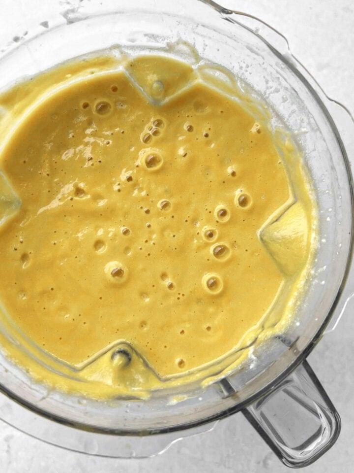 A food processor with freshly blended butternut squash soup.