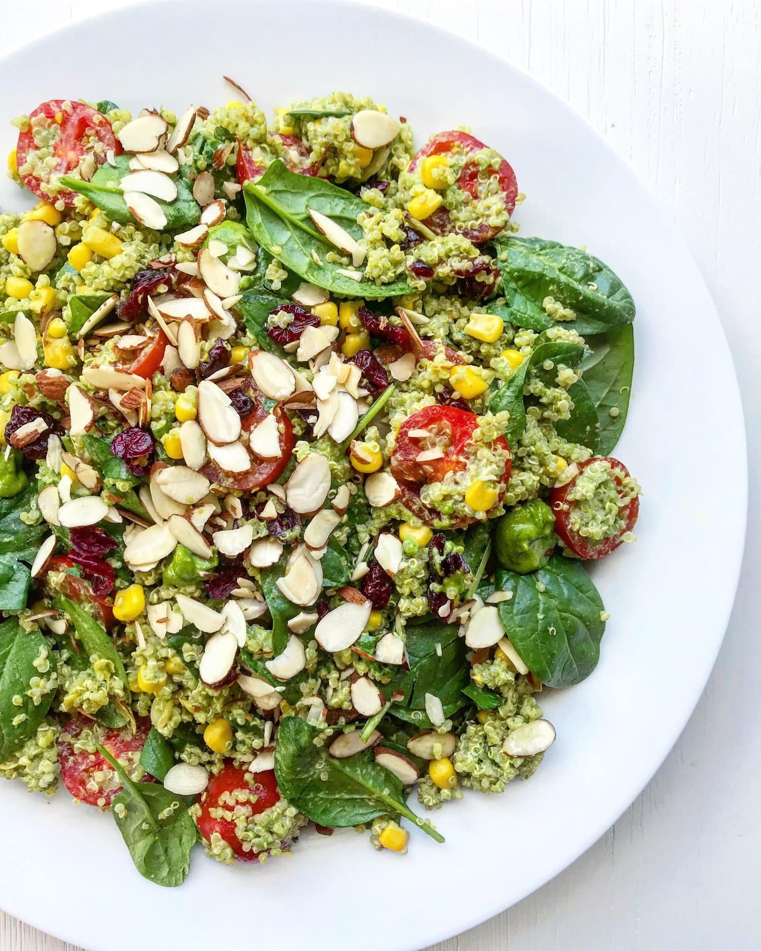 A large plate of cranberry pesto salad with flaked almonds.