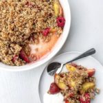 Summer fruit berry and nectarine crumble being served with yoghurt.