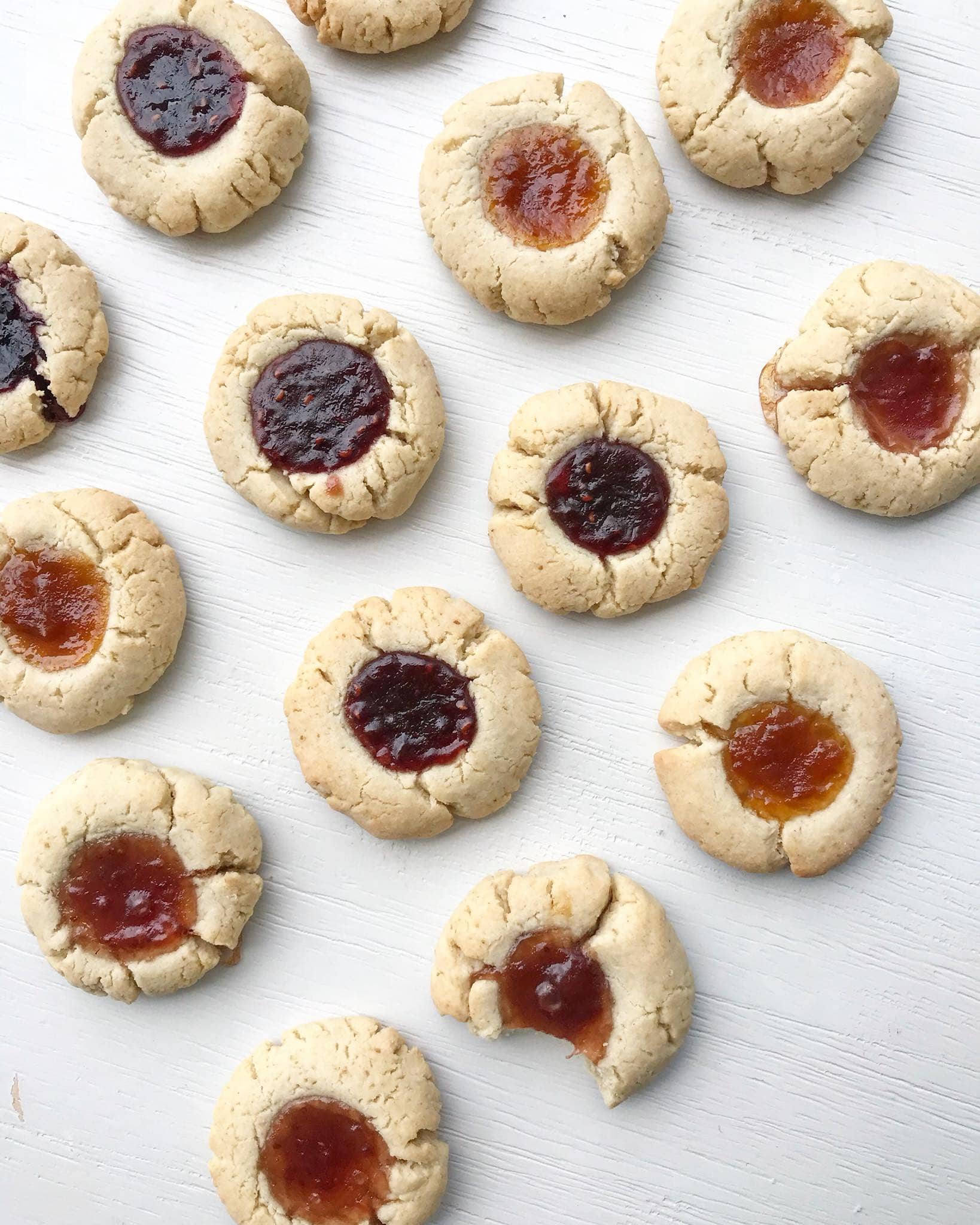 A group of gluten-free jam drop biscuits with different jams in the middle.