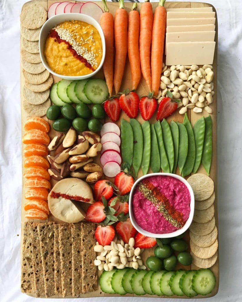 A plant-based vegan platter with fruit, vegetables, dairy-free cheeses, crackers and nuts. 