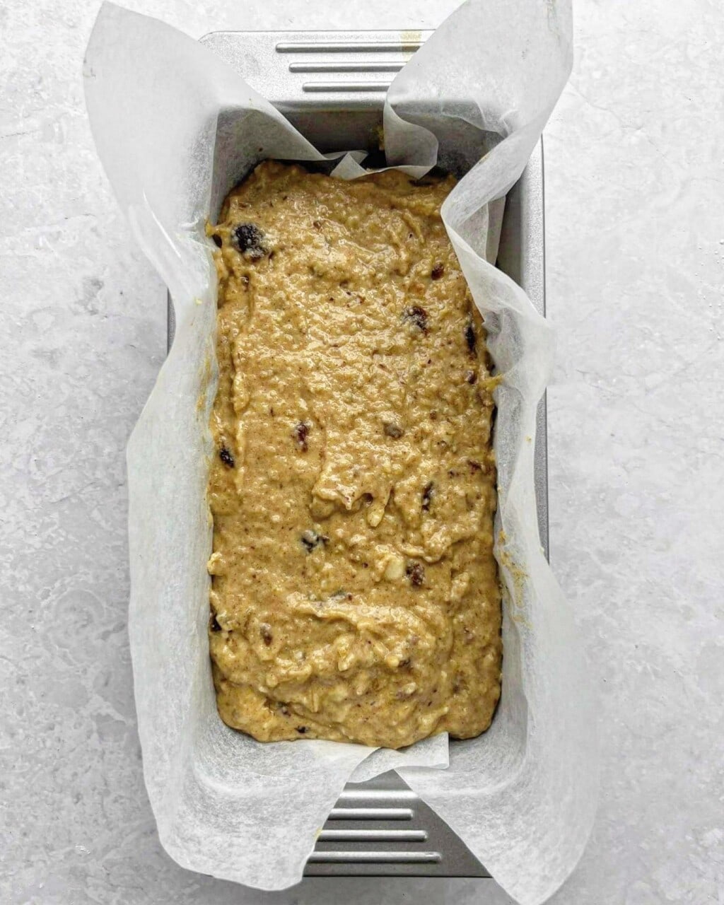 Banana date loaf batter in a lined loaf tin.