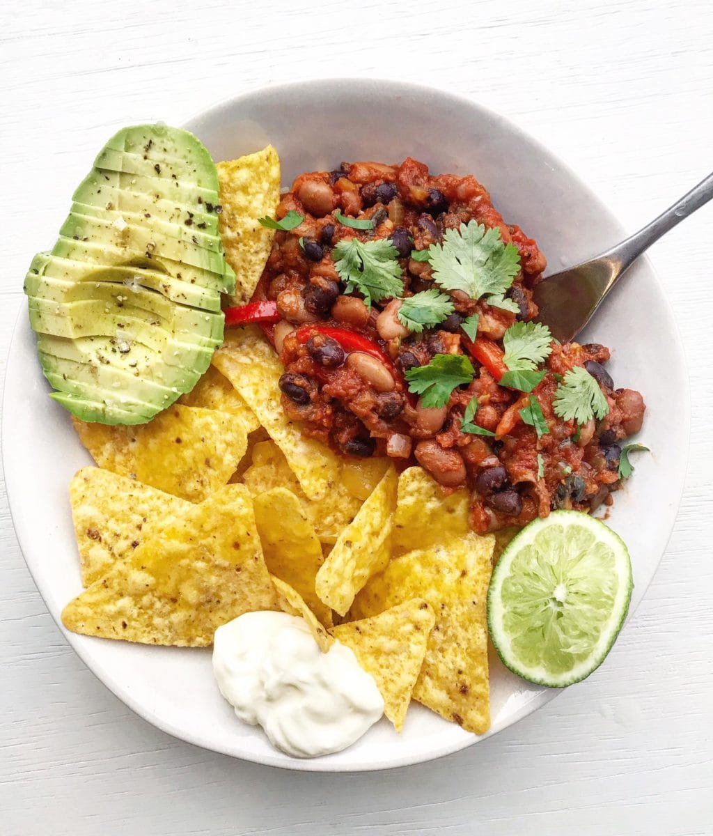 A bowl of vegan chili sin carne with garnishes. 
