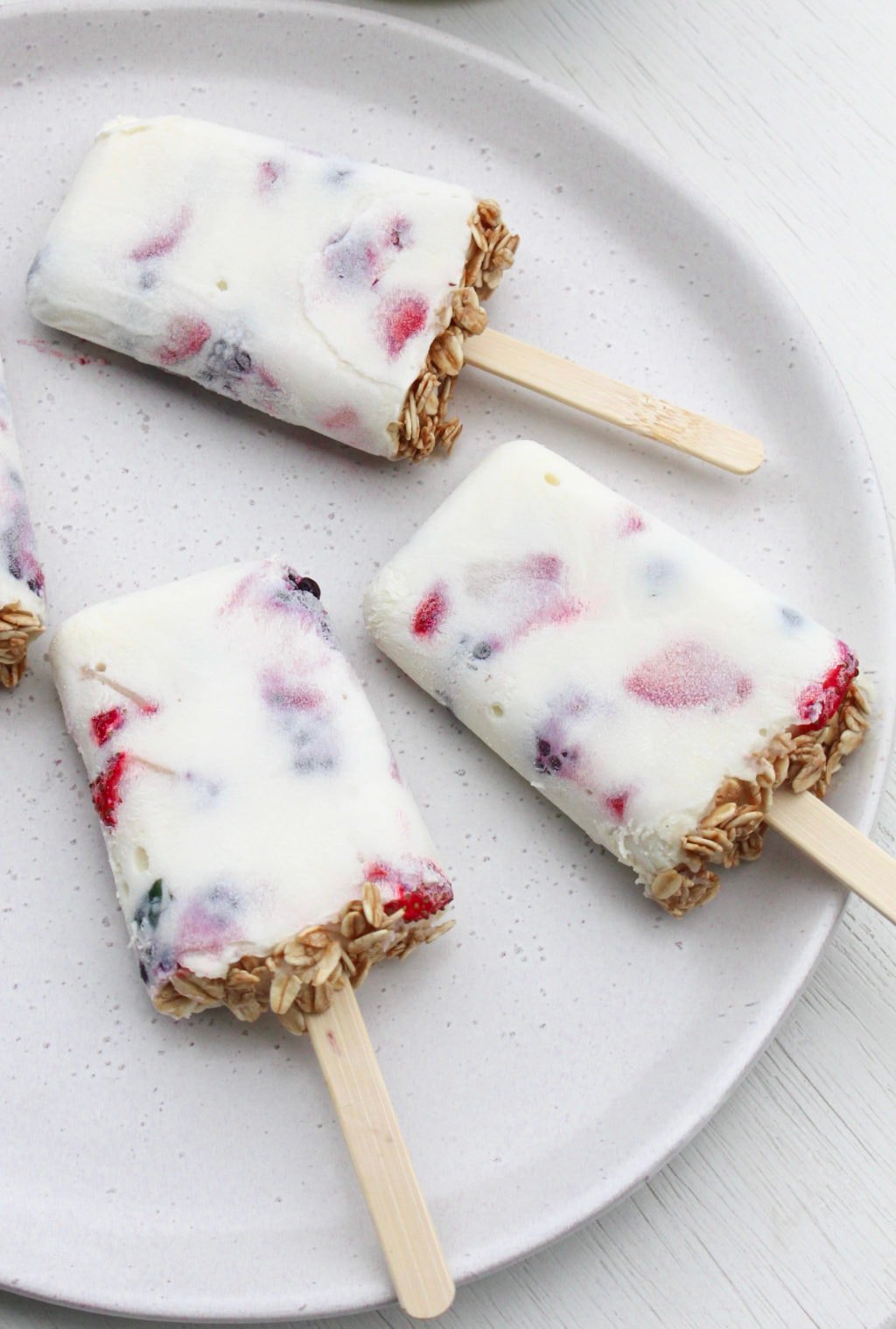 Breakfast yoghurt popsicles on a white plate.