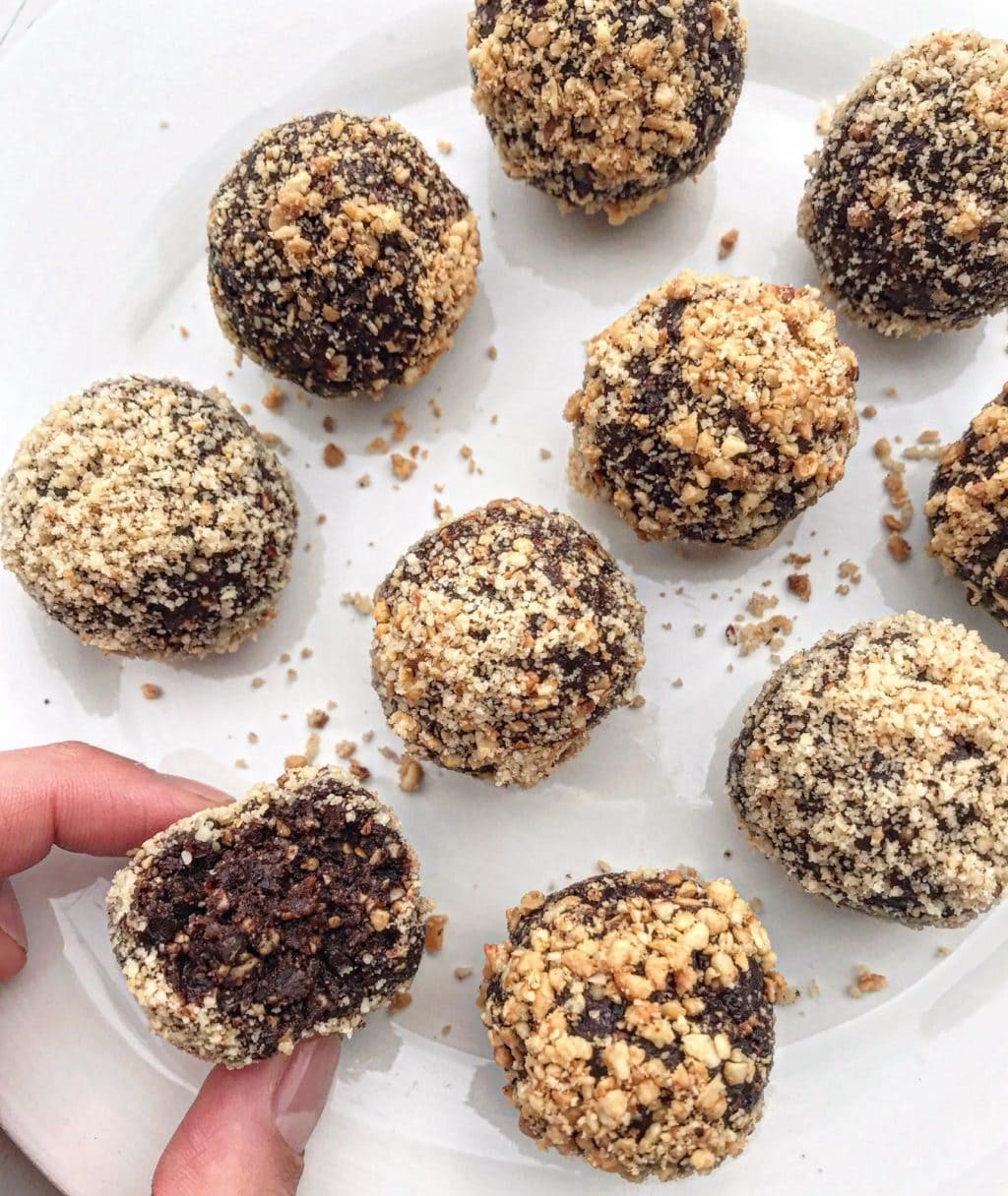 A picture of chocolate hazelnut bliss balls on a white plate. 