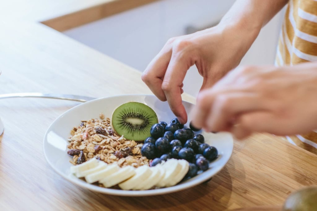 A bowl of muesli and fruit being made.