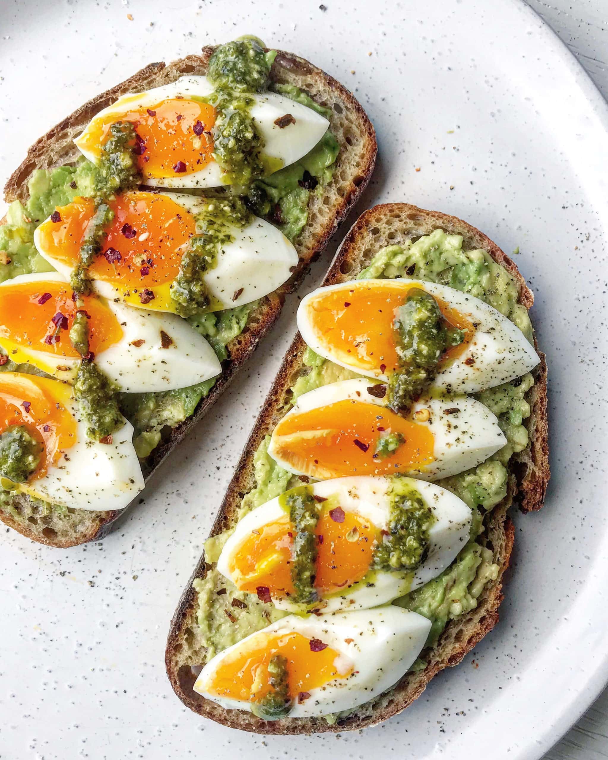 Avocado, boiled eggs and pesto on sourdough toast