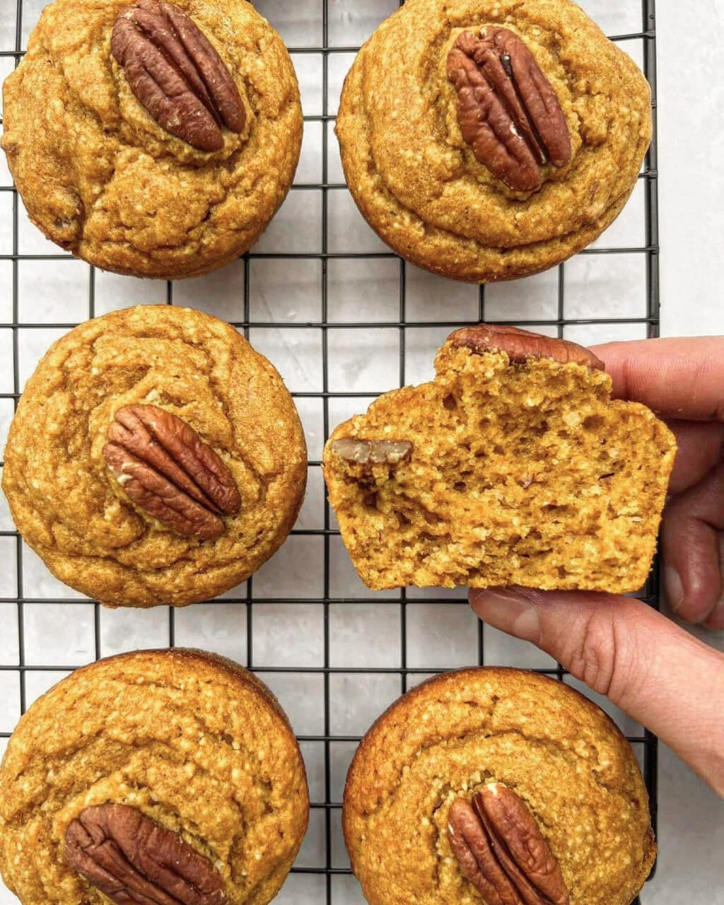 Freshly baked healthy pumpkin muffins topped with a pecan