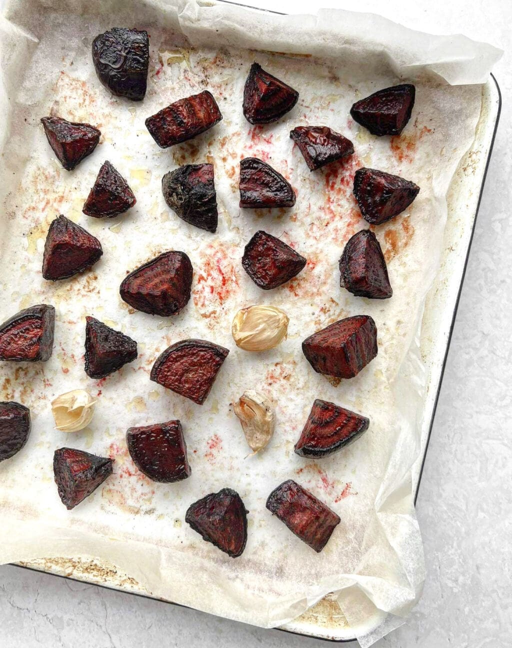 Roasted beetroot and garlic on a baking tray.