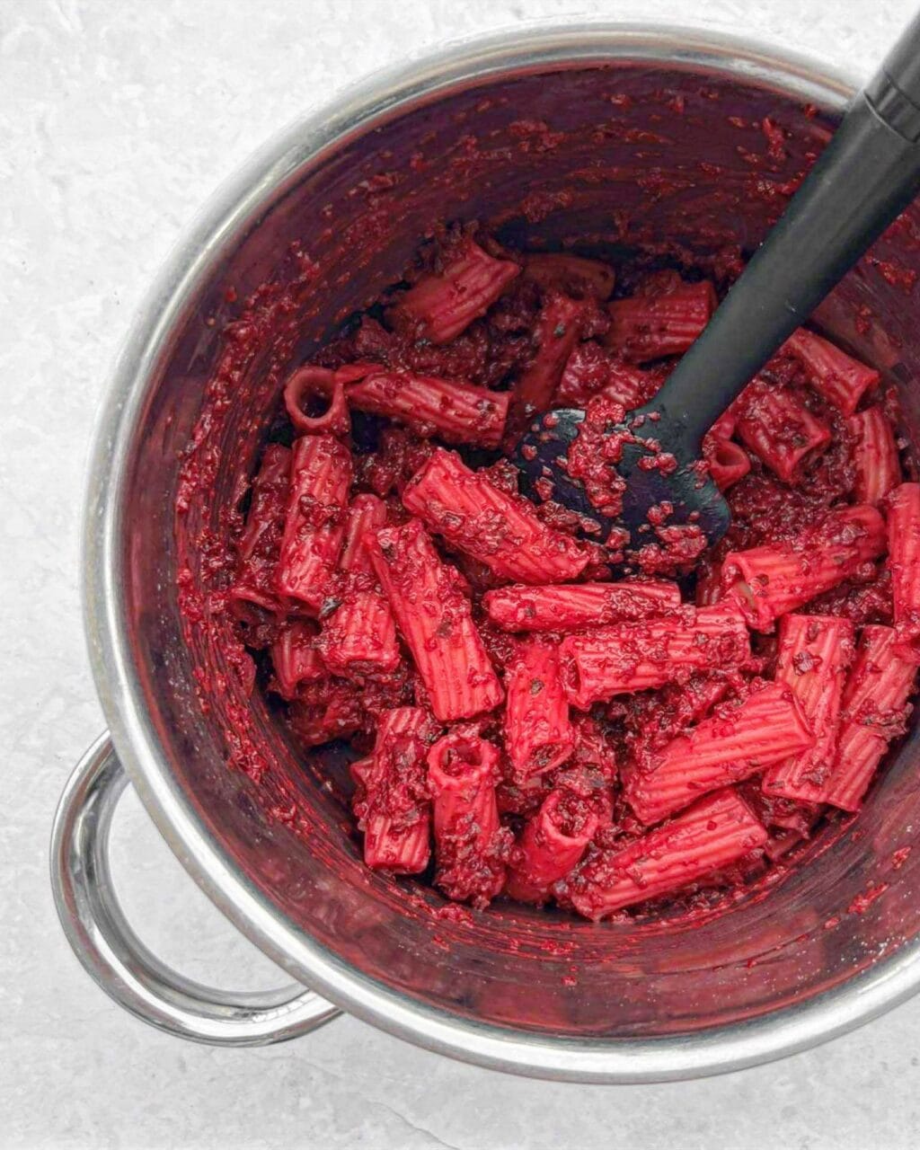 The cooked pasta tossed with the beetroot goat cheese sauce.