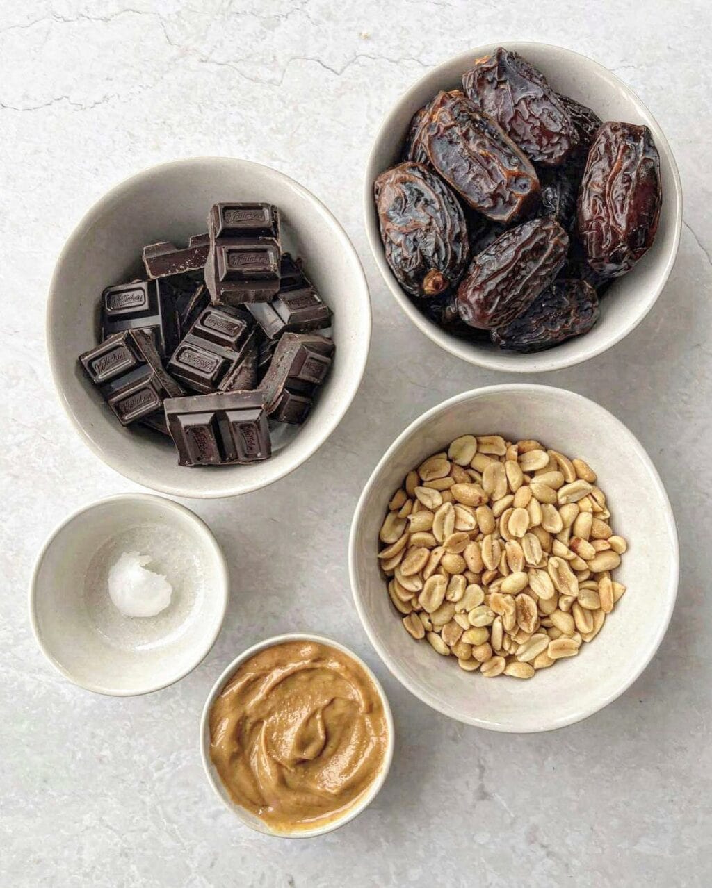Ingredients for peanut chocolate date bark including dark chocolate, medjool dates, salted roasted peanuts, coconut oil and peanut butter