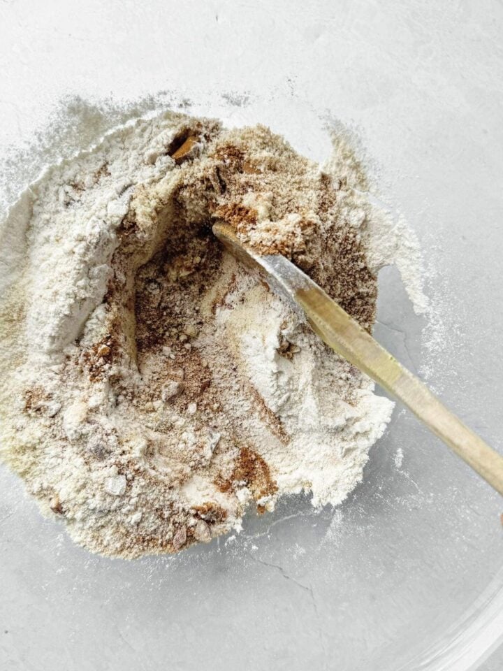 A bowl with the dry ingredients mixed together to make pumpkin pecan muffins.