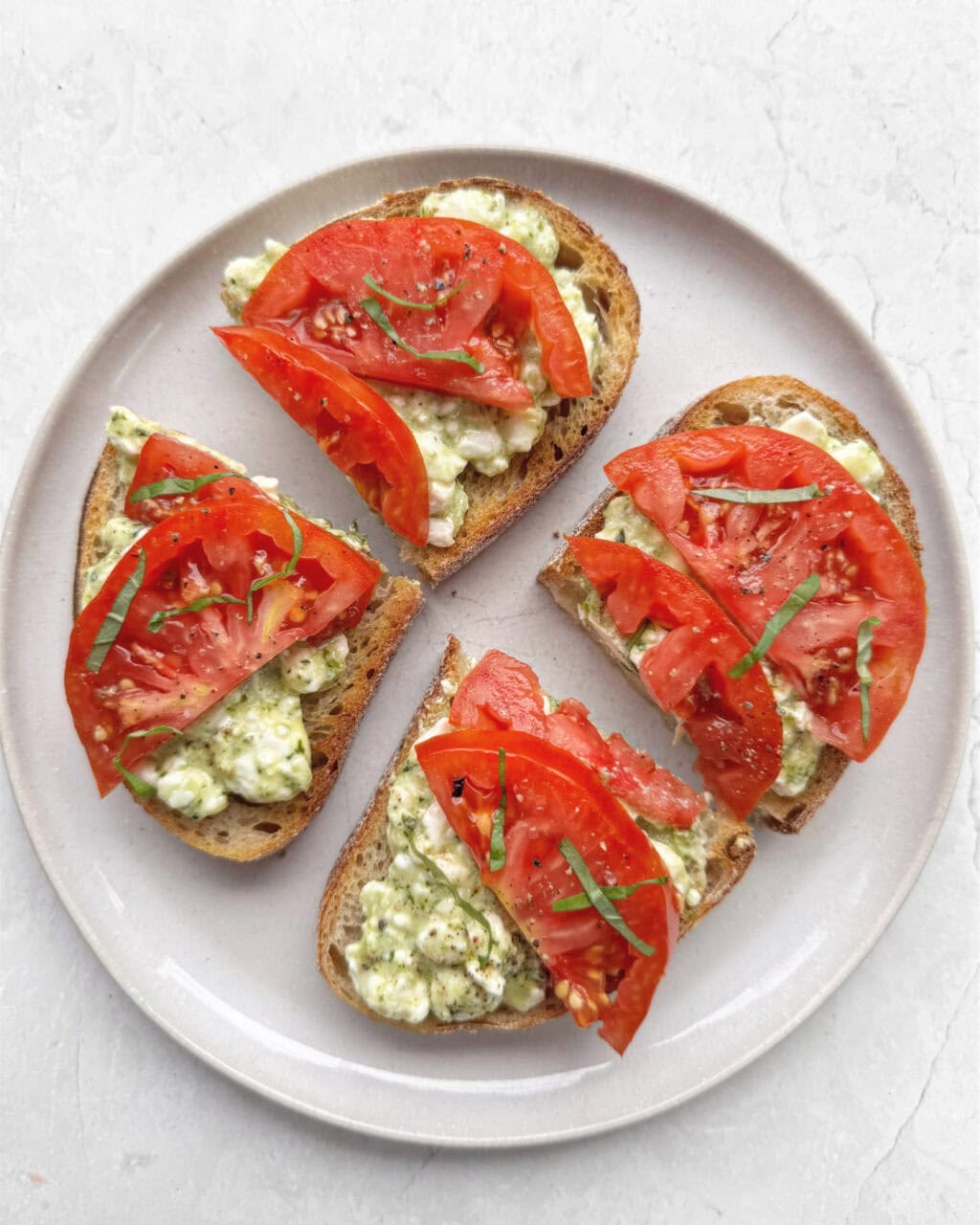 Pesto and cottage cheese toast topped with tomato.