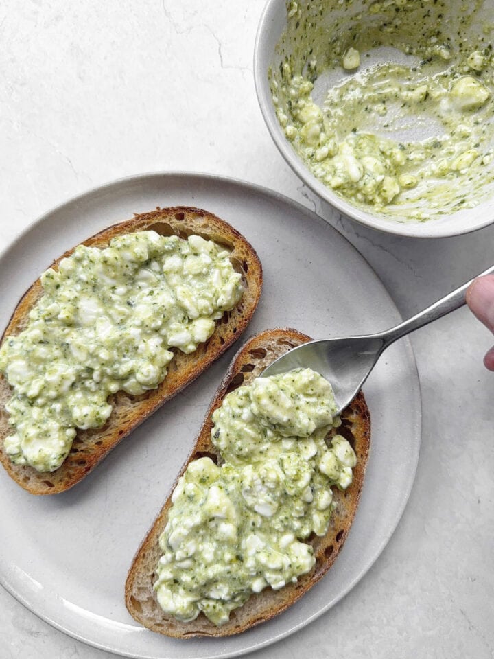 Spreading pesto cottage cheese onto sourdough